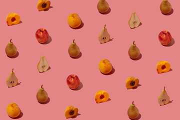 Creative pattern made with fresh pears and peaches on pastel pink background. Minimal summer fruit arrangement.