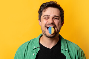 Guy in green shirt show tongue with Ukrainian flag