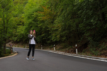 Obraz premium the girl is talking on the phone on the road
