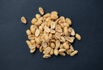 Salted peanuts on a dark background.