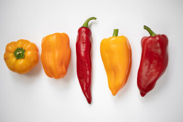 Red and yellow peppers. Peppers of different varieties on white.