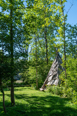 A replica Anishinaabe wigwam is nestled in a forest at Fort William National Historic Site in...