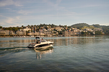 Motor boat floating in river at sunset in Switzerland