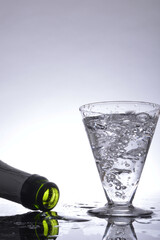 Glass of bubbling champagne and bottle