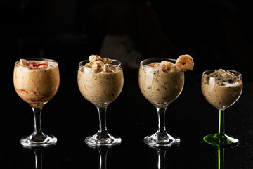 Ceviche peruano, vegetariano y de camarones servidos en copas con un fondo negro