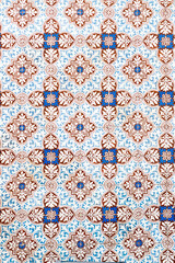 Traditional decorative mosaic of portuguese tiles in browns and blue color with complex form 