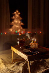 christmas decorations at home, lights garlands on the Christmas tree for new year and Christmas. cake and candles for a birthday or Christmas Eve celebration. soft selective focus. celebration and