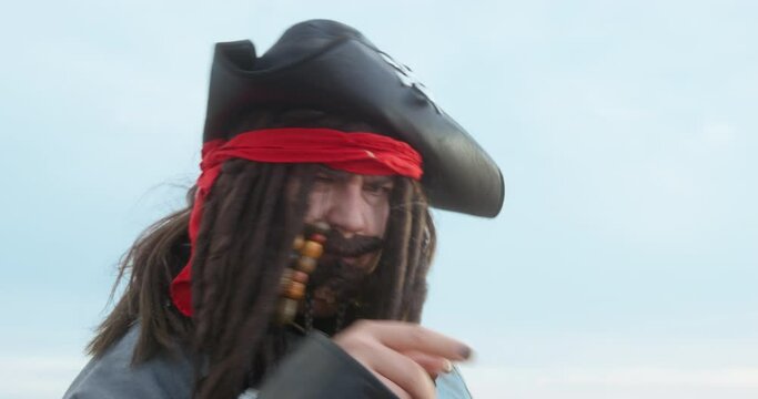 Cosplay, image of cute pirate in hat with dreadlocks, mustache, beard. Man in carnival costume of sea corsair, robber, halloween. Performance of animator at children's holiday. Pirate quest