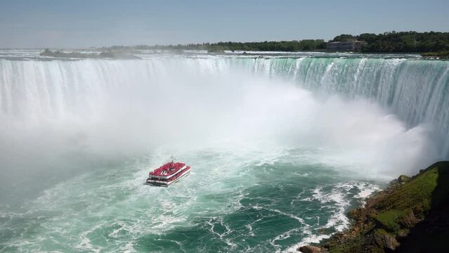 Locked-off shot of Niagara Falls showing tour boat approaching the famous Horseshoe waterfall on the border of US and Canada.