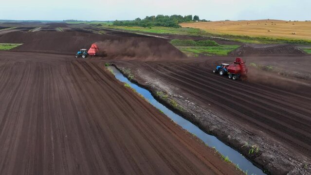 Peat Harvester Tractor on Collecting Extracting Peat. Mining and harvesting peatland. Area drained of the mire are used for peat extraction. Drainage and destruction of peat bogs. 