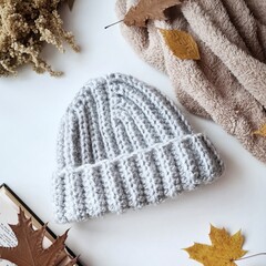 Fototapeta na wymiar Fashionable knitted hats autumn-winter. The hat lies on a white background. Product layout. Buy a hat. Knitting. Hobby.