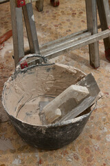 A trowel, a carrycot with plaster and a ladder, tools of a mason reforming interiors,