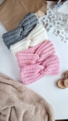 Fototapeta na wymiar Fashionable knitted headbands autumn-winter. The headbands lies on a white background. Product layout. Knitting. Hobby.