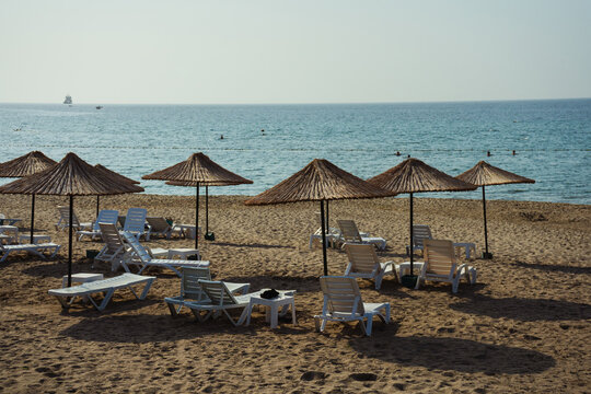 clean beach in istanbul city. sandy beach with wooden umbrellas in turkey. private club promenade for villa residents
