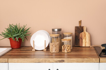 Cutting boards and jars with food on counters near beige wall