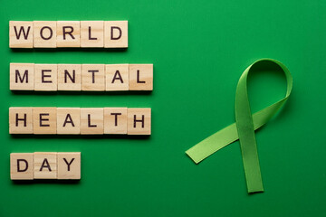World Mental Health Day. Green ribbon on green background.