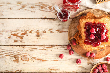 Plate with tasty toasts and raspberry jam on white wooden background