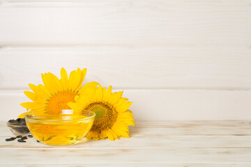 Sunflower oil, seeds and flower on wooden background