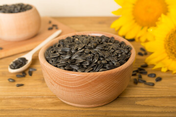 Sunflower seeds and flowers on wooden table