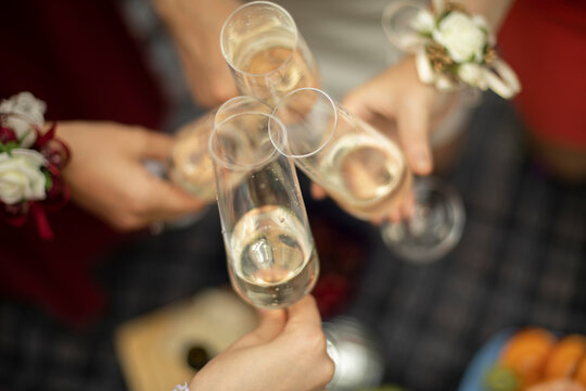 Glasses with champagne in hand. Wine by glass. Outdoor celebration details. Glass glass glass with drink.