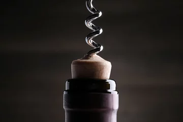 Fotobehang Opening wine bottle with corkscrew on dark background, closeup © New Africa