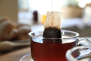 Fototapeta Tea bag in glass cup on table indoors, closeup obraz