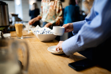 Coffee tasting, close-up of a girl's hands with a cup of coffee on the background of the table