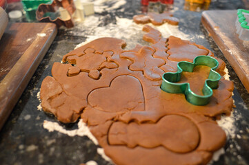 gingerbread cookie dough rolled out on the counter tip with flour and cookie cutters for Christmas