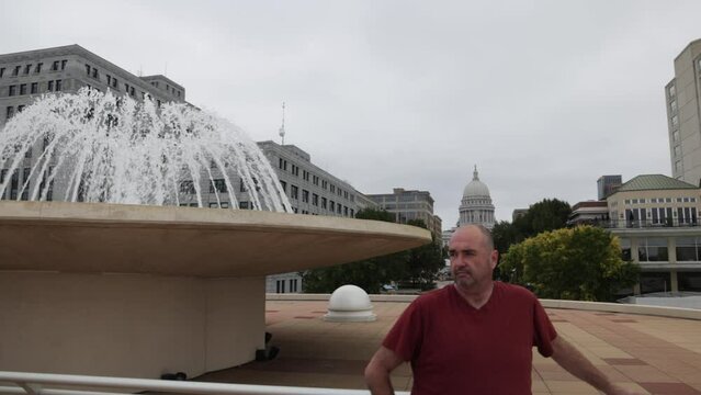 Monona Terrace in Madison, Wisconsin with video panning left to right showing caucasian man in front of water fountain.