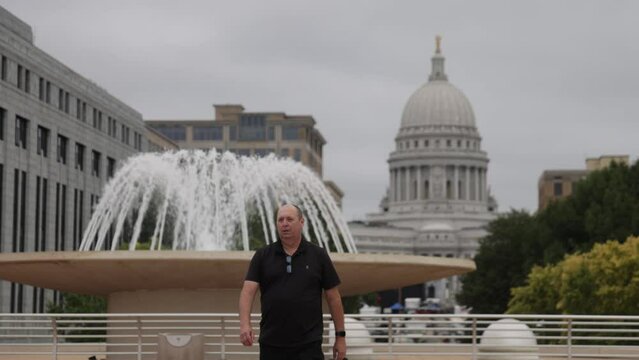 Caucasian male in black clothes walking towards camera on Monona Terrace in Madison, Wisconsin.
