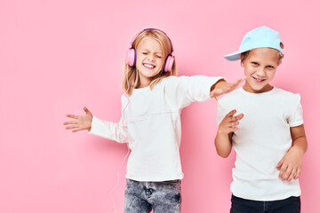 Funny children are playing together pink color background