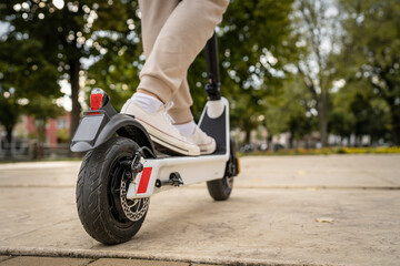 unknown man standing or driving electric kick scooter e-scooter