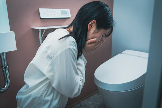 トイレで嘔吐する女性　vomiting