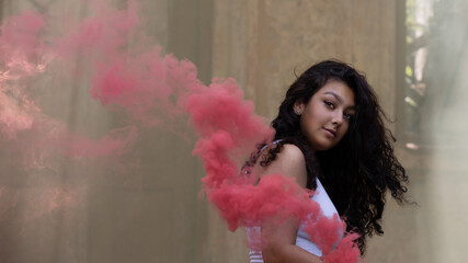 Young girl posing with smoke bomb in an abandoned place
