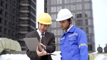 Professional Asian foreman and construction manager talking - discussing together.