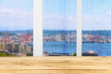 Wood  table with window glass and city background.