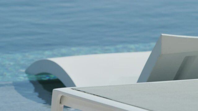 Close up rack focus on white modern lounge chair in pool on sunny day