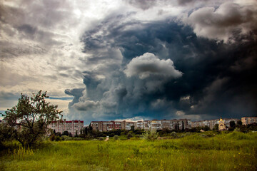 Fototapeta na wymiar City houses under the sky before heavy rain