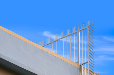 Low angle view of metal spike fence on rooftop of tenement building for security concept