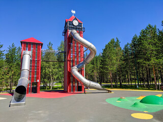 Noyabrsk, Russia - July 13, 2022: View of the playground in the city park. For children there are slides in the form of high metal red towers
