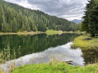 Fototapeta premium Alpine mountain lake Schwarzsee or Black Lake between the tourist towns of Davos and Klosters - Canton of Grisons, Switzerland (Kanton Graubünden, Schweiz)