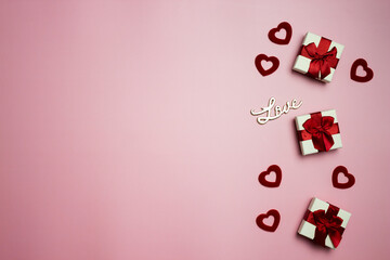 Gift boxes with red hearts with love letters over the pink background. 
