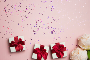 White gift box with glitter over the pink background. 