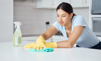 Obraz na płótnie Canvas Cleaner woman cleaning kitchen counter with cloth, spray bottle and rubber gloves in modern home interior. Service worker working with soap liquid, hygiene equipment or wipe surface for spring clean