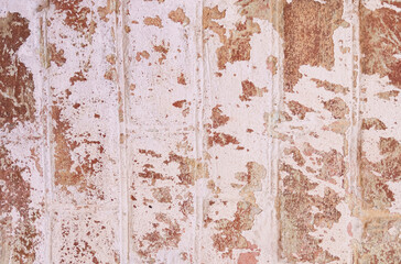 Background texture of a brick wall with old white crumbling paint.