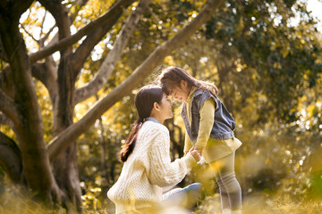 Fototapeta premium young asian mother and daughter enjoying a good time in park