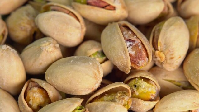 Hot roasted pistachios rotate with smoke. Salted pistachio nuts for beer background close up. Vegan Healthy food high protein. Dietary nutrition. Concept of nuts.