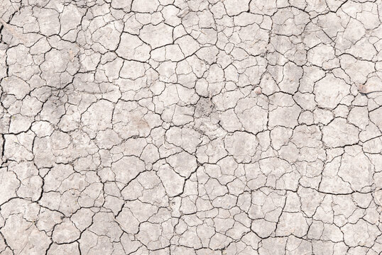 Surface of a grungy dry cracking parched earth for textural background.