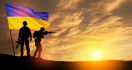 Flag of Ukraine with silhouette of soldiers against the sunrise or sunset. Concept - armed forces of Ukraine.