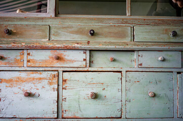 Old worn sideboard in light blue with many drawers and chipped paint.